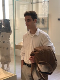a man in a white shirt standing in front of a display case